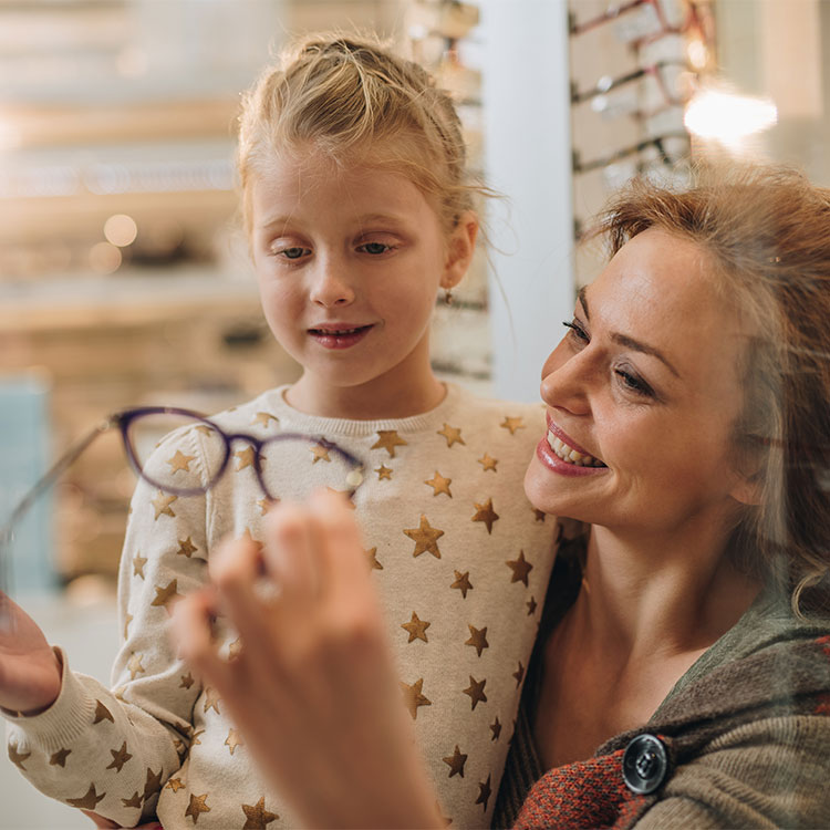 Woman and young daughter shopping for eyeglasses